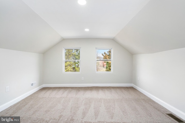 additional living space featuring vaulted ceiling, baseboards, visible vents, recessed lighting, and carpet floors