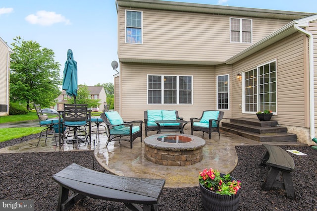 rear view of house featuring a patio and an outdoor living space with a fire pit