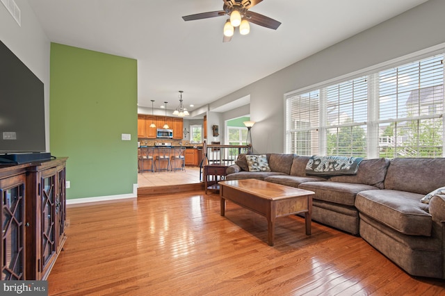 living room with light wood-type flooring, a ceiling fan, baseboards, and recessed lighting
