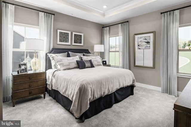 bedroom featuring light carpet, baseboards, a tray ceiling, and recessed lighting