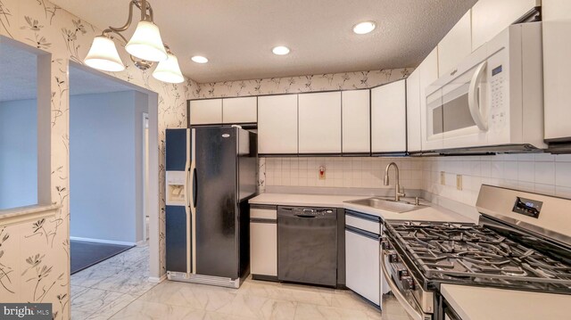 68 Arapaho Pl, Galloway, NJ 08205 - kitchen with a sink, wallpapered walls, black appliances, light countertops, and white cabinetry