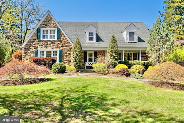 cape cod-style house featuring a front lawn and stone siding