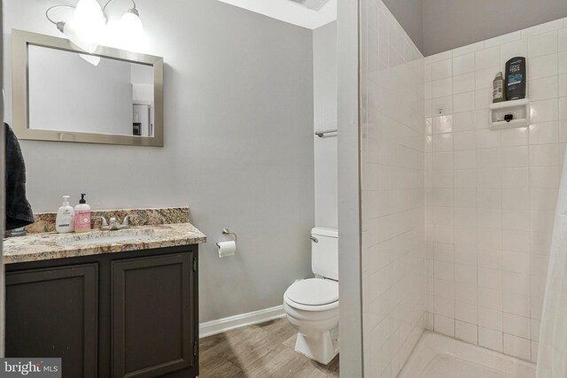 2102 Whisperwood Glen Ln, Reston, VA 20191 - full bathroom featuring vanity, toilet, baseboards, wood finished floors, and tiled shower