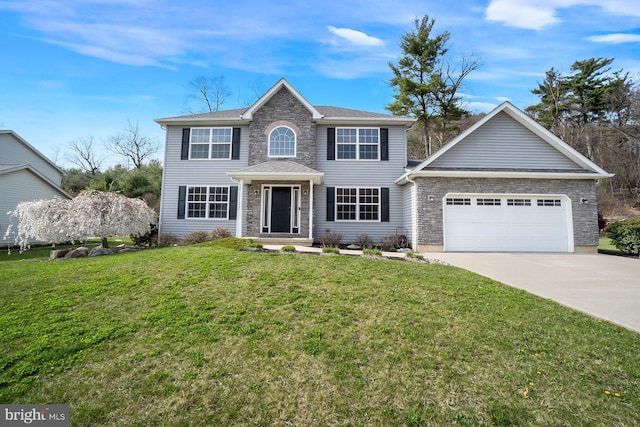 colonial home with a garage, a front lawn, and concrete driveway