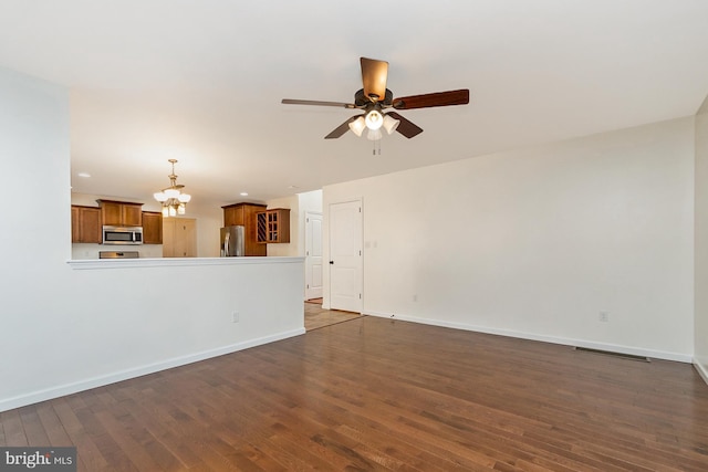 unfurnished living room featuring recessed lighting, baseboards, dark wood-type flooring, and ceiling fan with notable chandelier