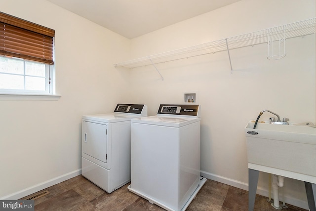 laundry room with baseboards, visible vents, washer and dryer, and laundry area
