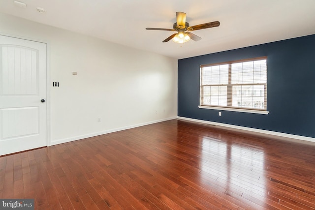 unfurnished room featuring wood finished floors, baseboards, and ceiling fan