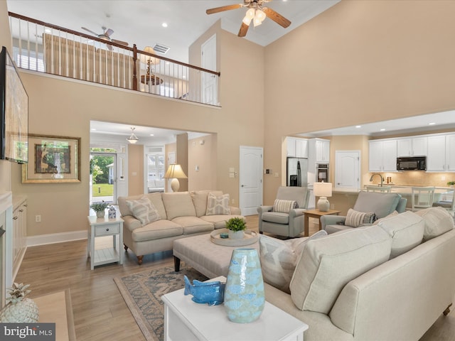 11733 Maid At Arms Ln, Berlin, MD 21811 - living room with ceiling fan, light wood-style flooring, baseboards, and a high ceiling