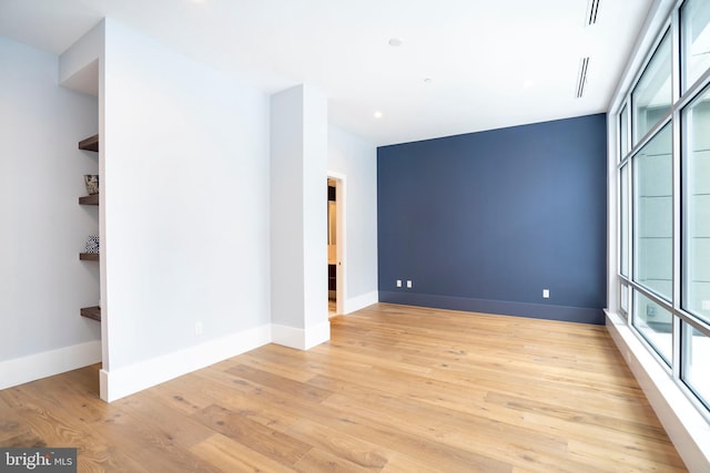 empty room featuring baseboards and light wood-style flooring