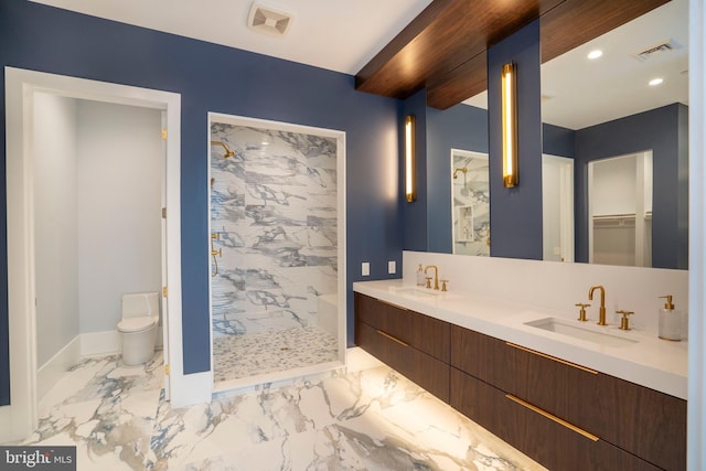 bathroom featuring toilet, a shower stall, marble finish floor, and a sink