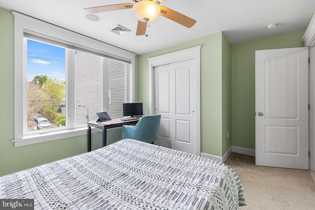 bedroom with a ceiling fan, a closet, light carpet, baseboards, and visible vents