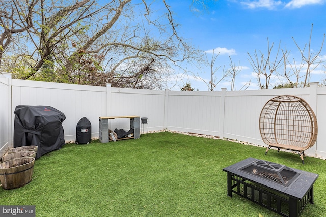 view of yard with a fenced backyard and an outdoor fire pit