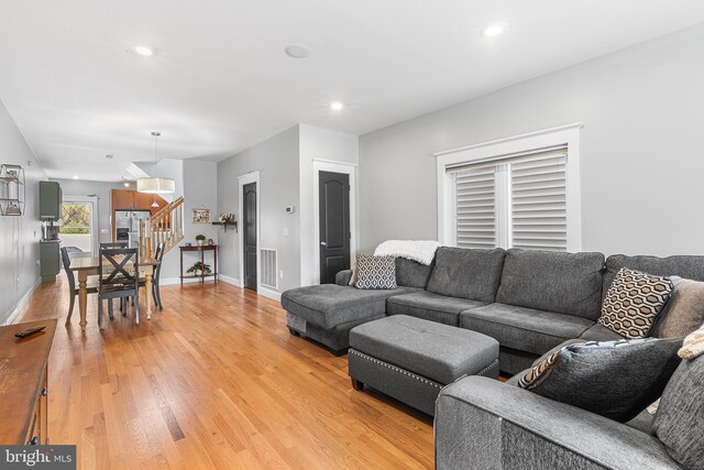 living room featuring recessed lighting, baseboards, visible vents, and light wood-style flooring