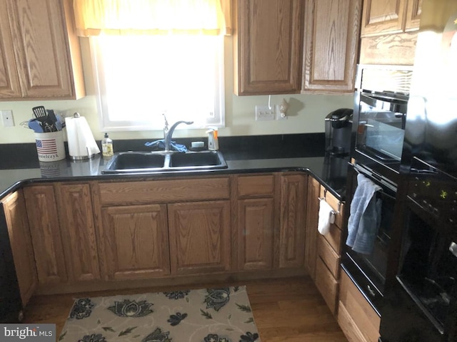 14121 Caine Stable Rd, Ocean City, MD 21842 - kitchen featuring dark countertops, black oven, wood finished floors, and a sink