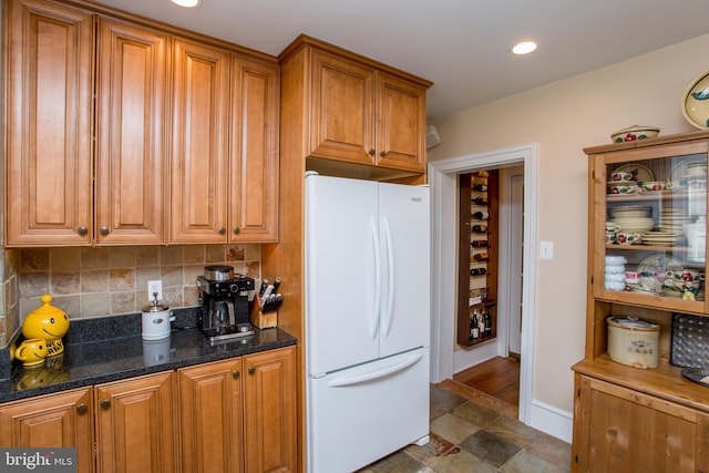 36 S Clinton St, Doylestown, PA 18901 - kitchen featuring dark stone counters, recessed lighting, decorative backsplash, brown cabinetry, and freestanding refrigerator