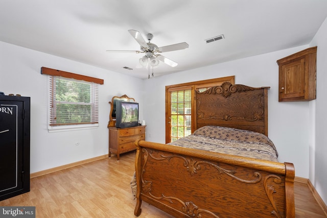 bedroom featuring visible vents, multiple windows, and light wood-style floors