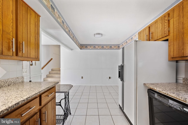 kitchen with tasteful backsplash, black dishwasher, brown cabinets, and light tile patterned flooring