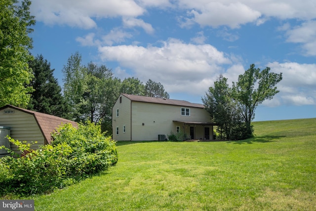 back of house with a lawn and central air condition unit