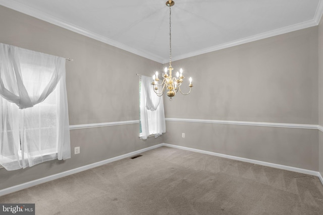 carpeted empty room featuring a chandelier, crown molding, and baseboards