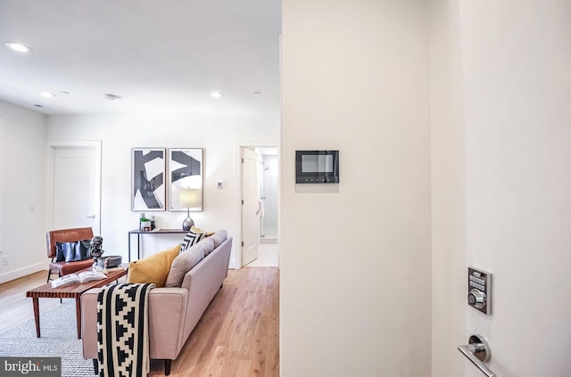 living room with recessed lighting, light wood-style flooring, and baseboards
