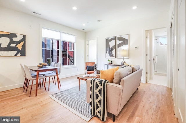living area with baseboards, recessed lighting, visible vents, and light wood-type flooring