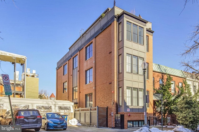 view of property featuring uncovered parking and fence