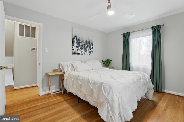 bedroom with baseboards, visible vents, a ceiling fan, and light wood-style floors
