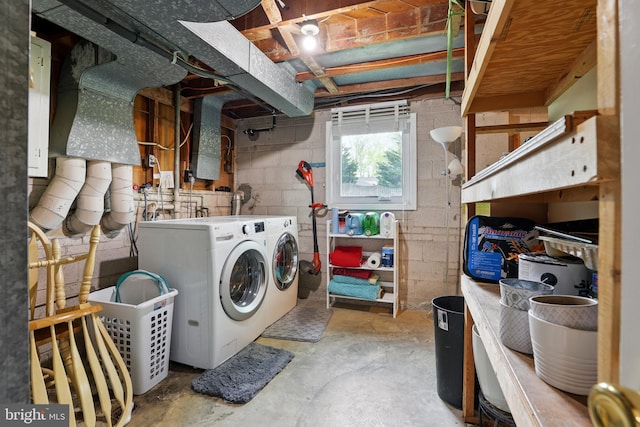 washroom featuring independent washer and dryer, concrete block wall, and laundry area