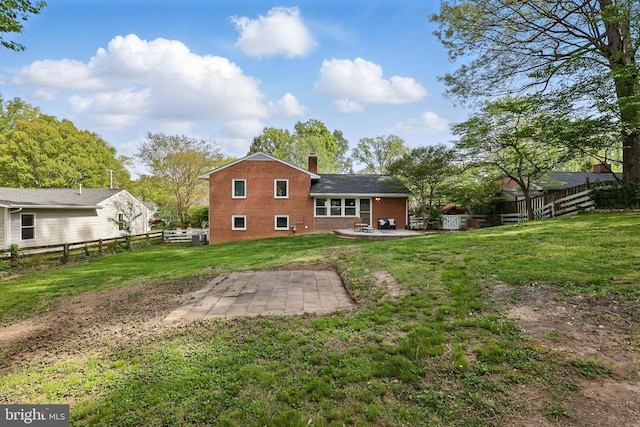 back of house featuring brick siding, a yard, a fenced backyard, and a patio area