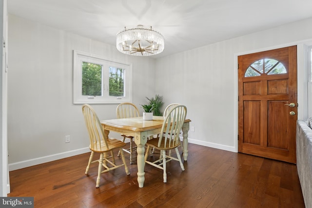 dining space with hardwood / wood-style floors, a chandelier, and baseboards
