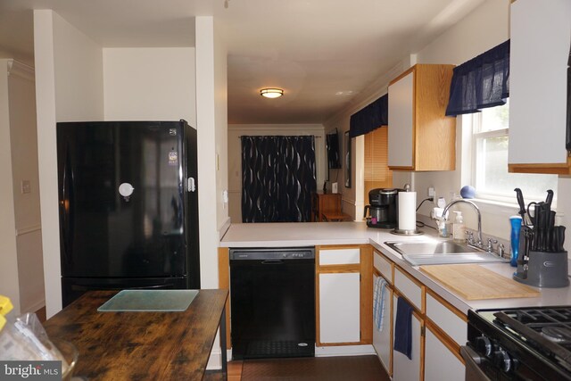 kitchen with a sink, black appliances, and light countertops