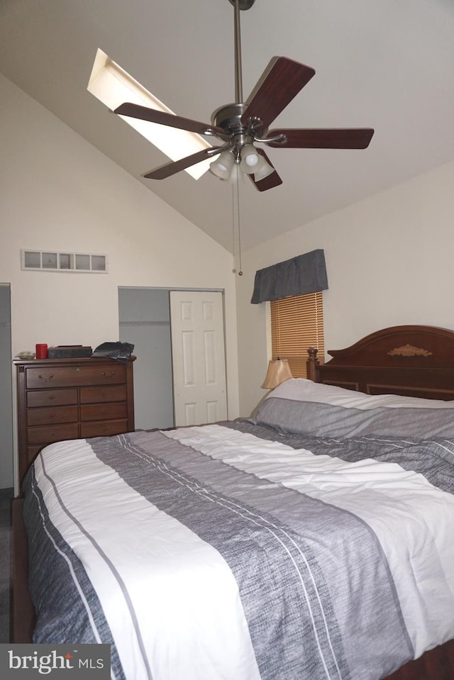 bedroom featuring ceiling fan, visible vents, lofted ceiling, and a closet
