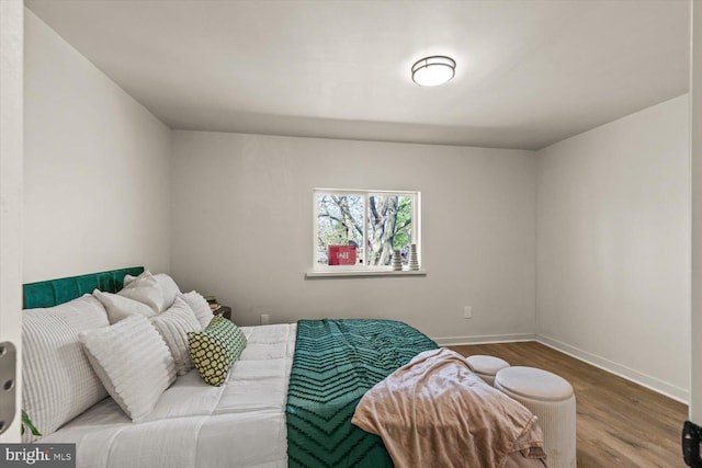 bedroom with baseboards and wood finished floors