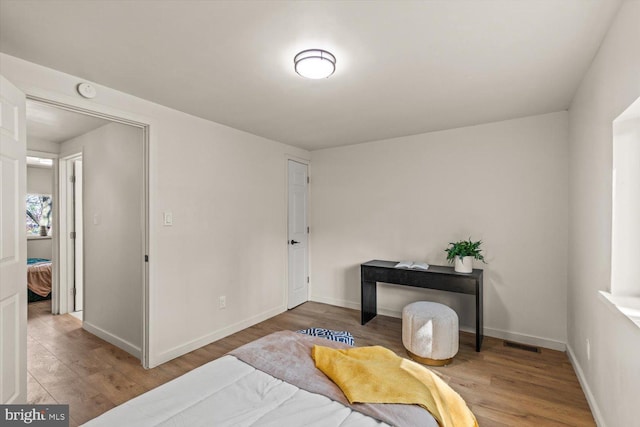bedroom featuring wood finished floors and baseboards