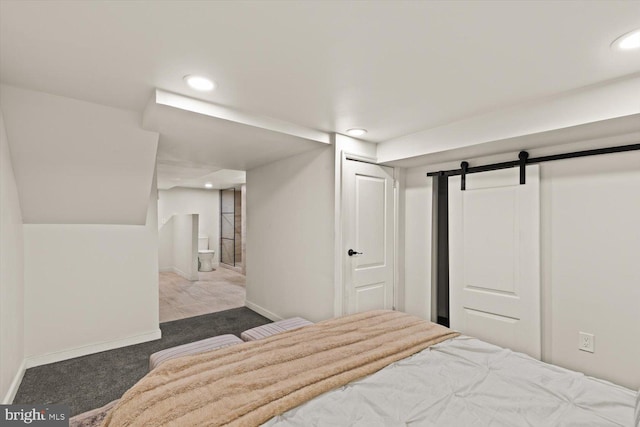 carpeted bedroom with ensuite bath, baseboards, recessed lighting, and a barn door