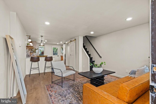 living area with stairway, baseboards, wood finished floors, and recessed lighting