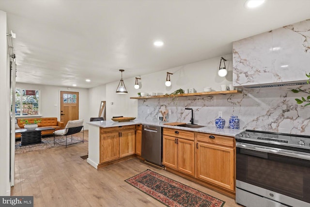 kitchen with tasteful backsplash, a sink, light wood-style floors, stainless steel appliances, and a peninsula