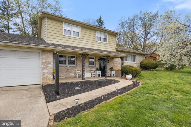 6 Shover Dr, Carlisle, PA 17013 - traditional home featuring a front lawn, driveway, a porch, brick siding, and an attached garage