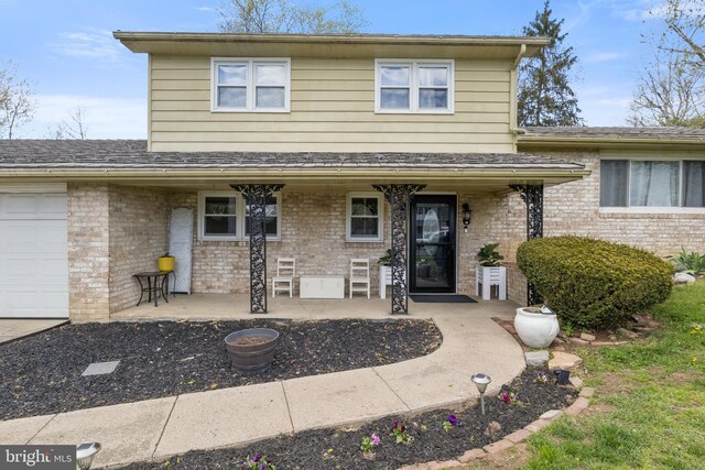 6 Shover Dr, Carlisle, PA 17013 - exterior space featuring an attached garage, brick siding, roof with shingles, and covered porch
