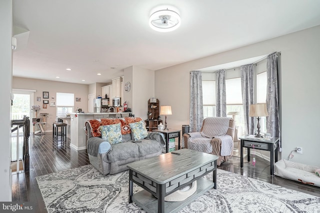 living room featuring dark wood-style flooring, baseboards, and recessed lighting