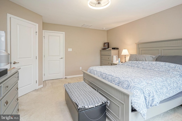 bedroom featuring baseboards, visible vents, and light carpet