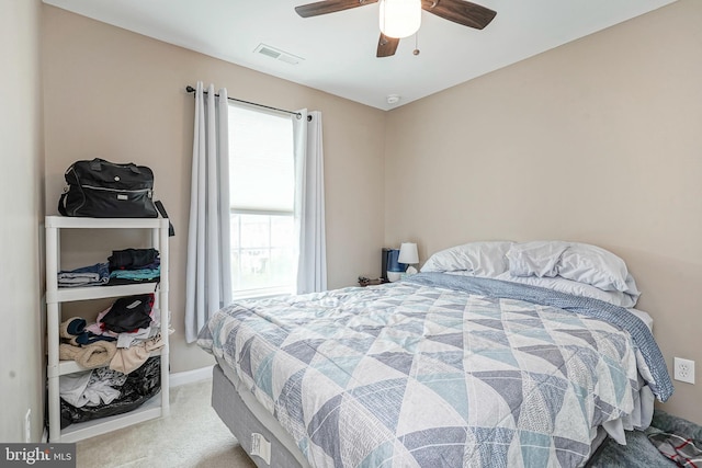 carpeted bedroom with visible vents, baseboards, and ceiling fan