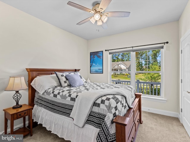 bedroom featuring light colored carpet, baseboards, and a ceiling fan
