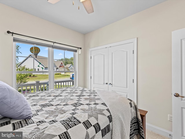 bedroom featuring a closet, baseboards, multiple windows, and access to exterior