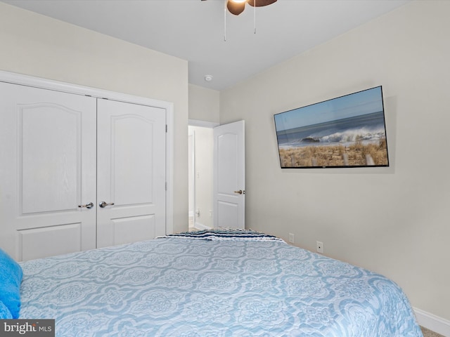 carpeted bedroom with a closet, baseboards, and ceiling fan