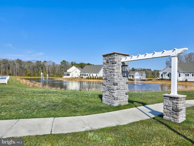 view of community featuring a lawn and a water view