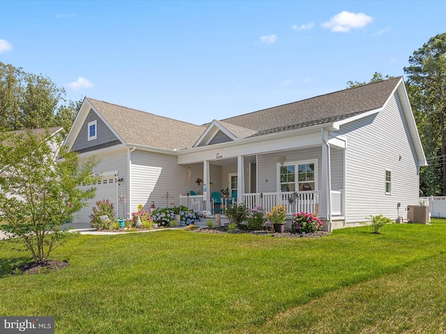 ranch-style house with roof with shingles, central AC, a front yard, and covered porch