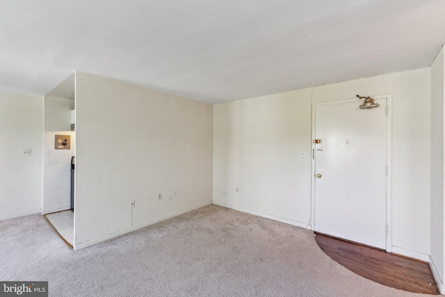 carpeted empty room featuring baseboards