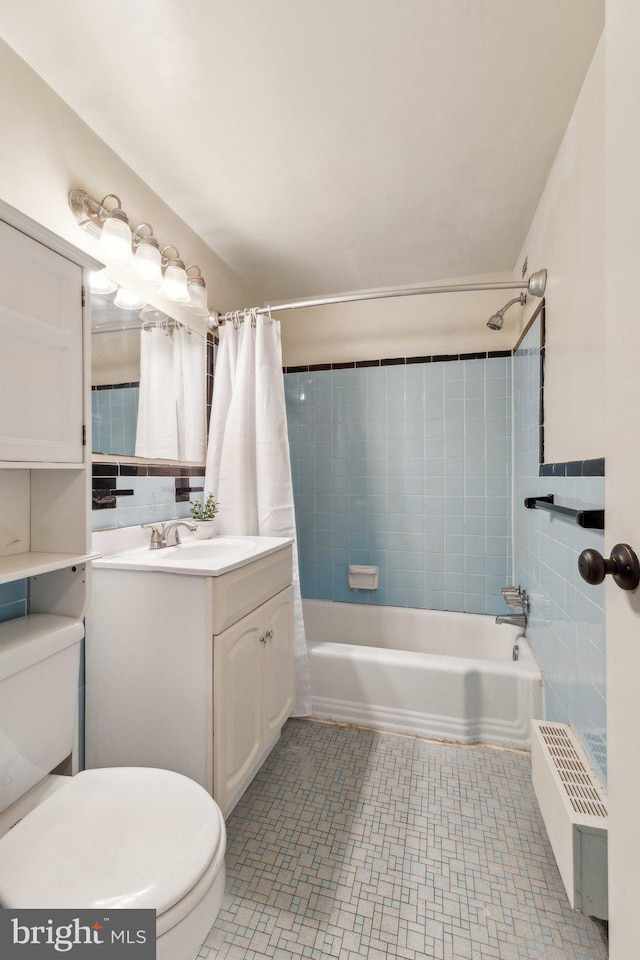 bathroom featuring shower / bath combo, vanity, toilet, and tile walls