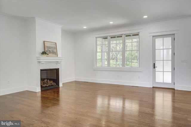 unfurnished living room featuring crown molding, baseboards, wood finished floors, and a fireplace